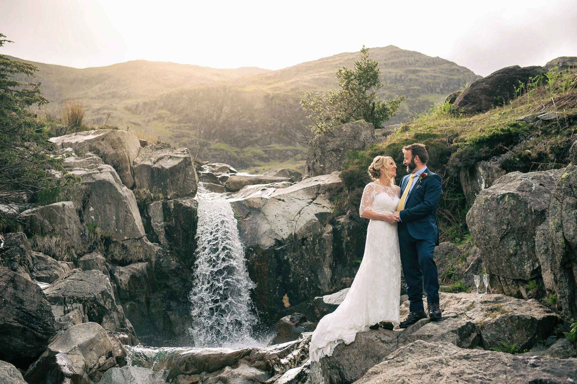 Bride and Groom portrait in front of a waterfall at sunset. Taken at Coniston Copper Mines in the Lake District
